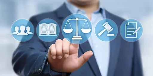 A man in a suit holding a button with icons of justice.