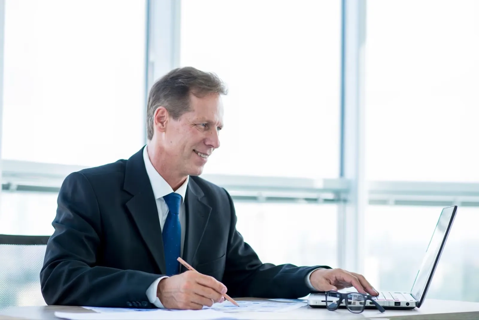 lawyer smiling while reading on his laptop
