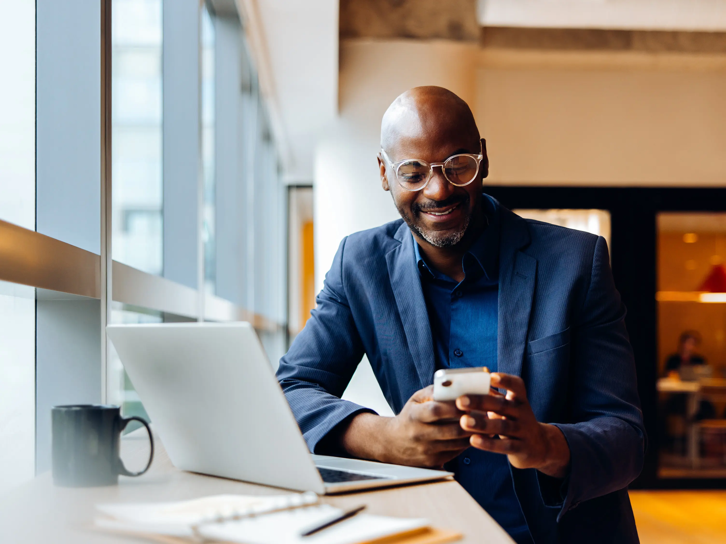 Lawyer in their office working on their computer while talking to someone on the phone.