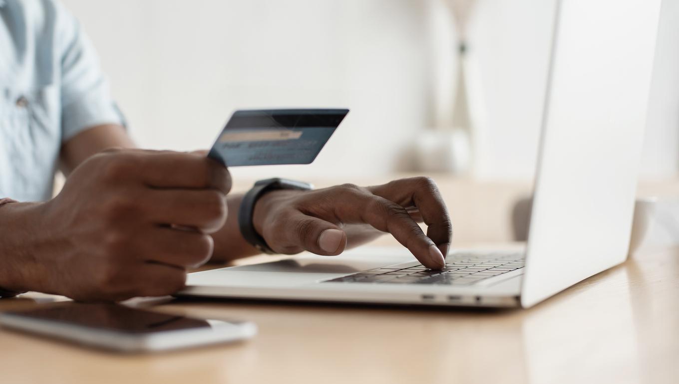 Person typing credit card details into laptop