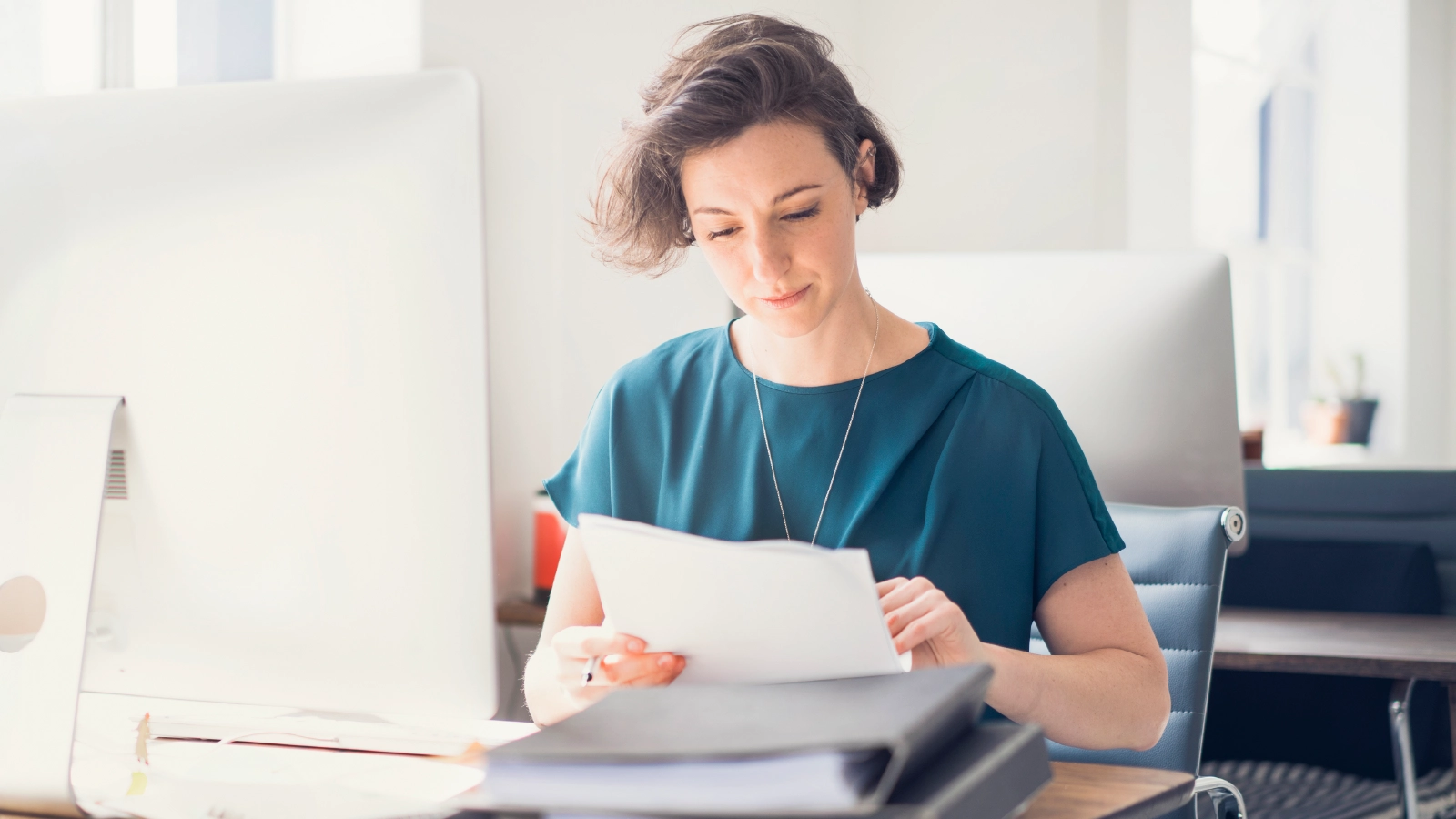 woman reading documents at desk