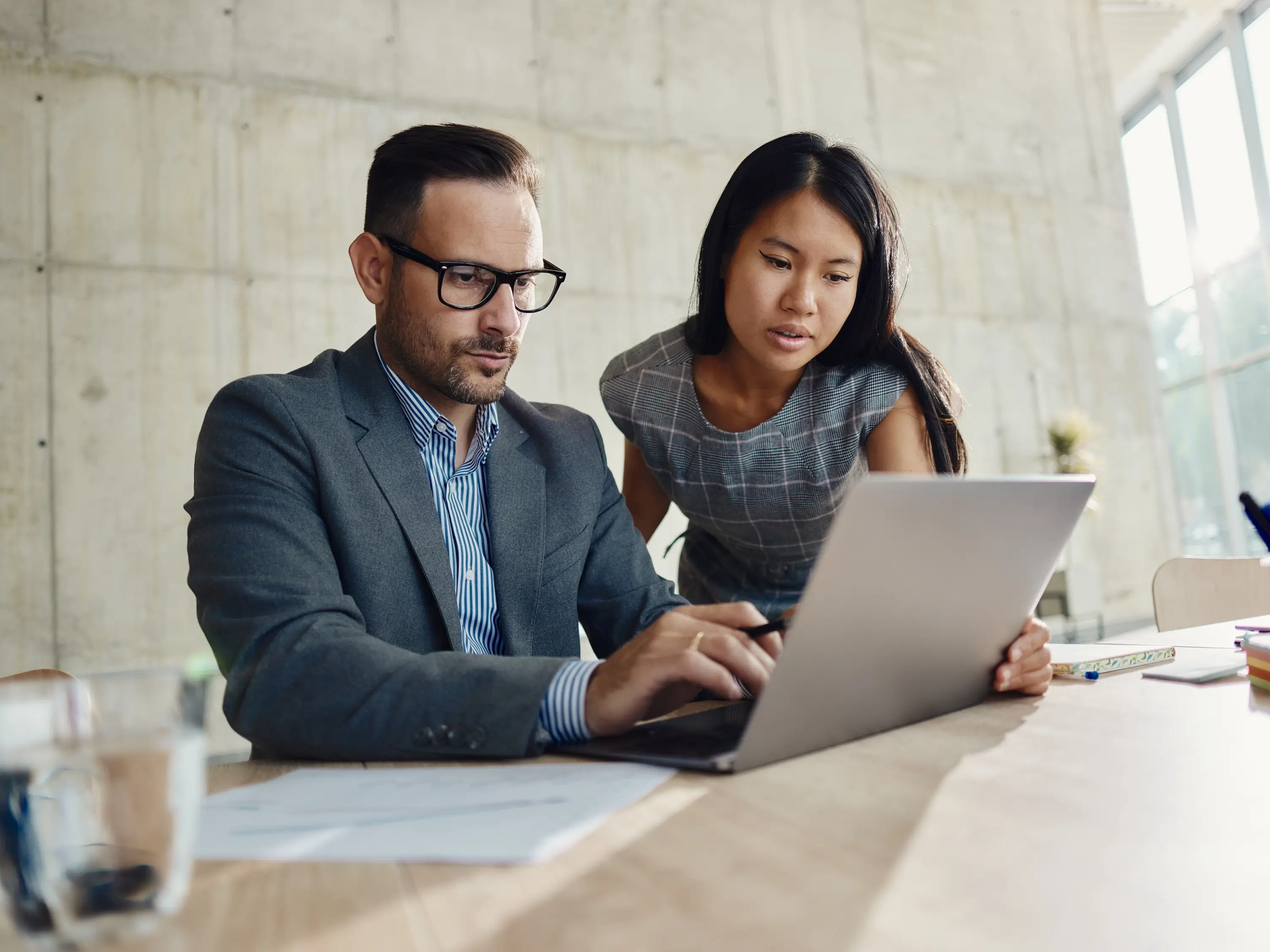 Lawyer working with another staff member on a computer to review client funds