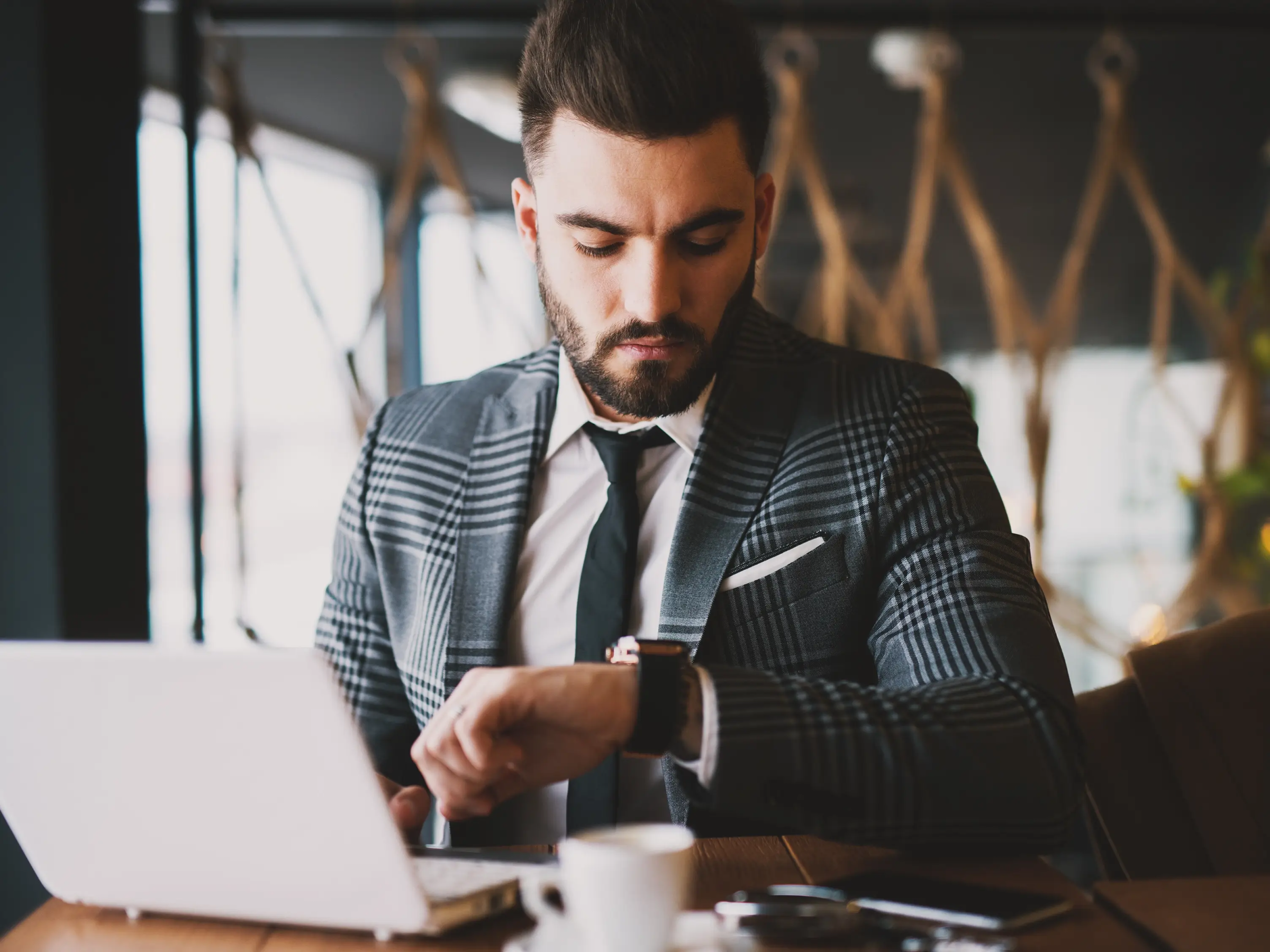 Lawyer working on their laptop and checking their watch to record time worked