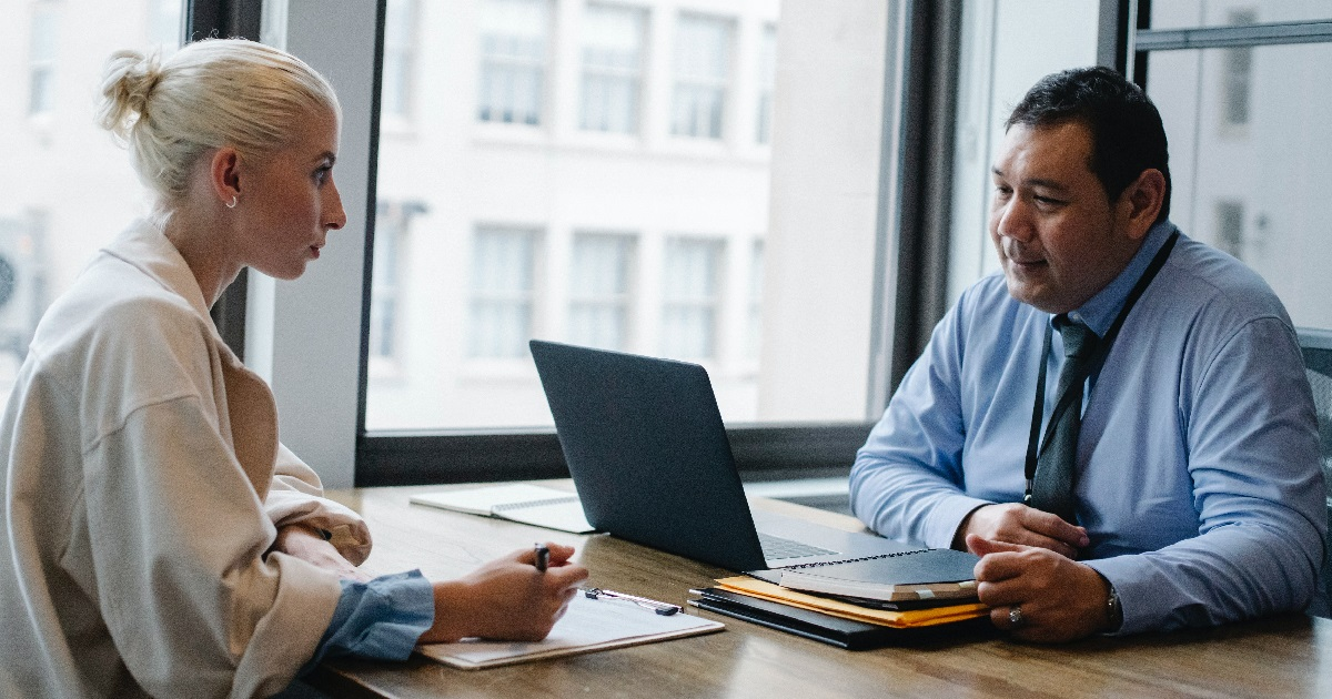 People sitting at a desk and talking to each other