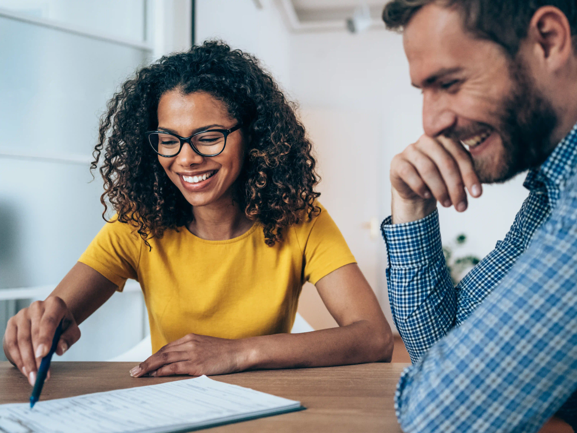 A person helping another person fill out a form