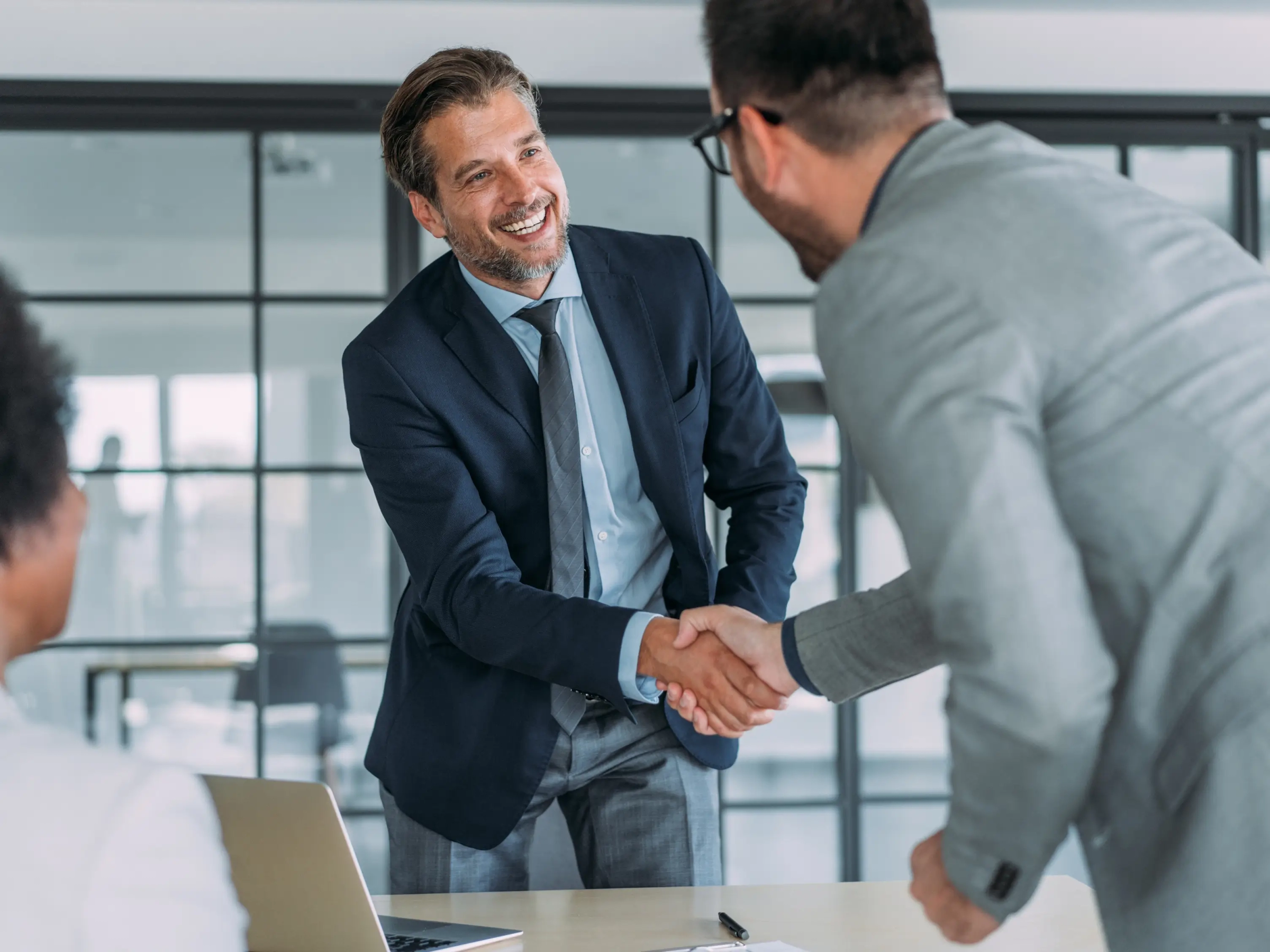 Lawyer shaking hands with a potential client before beginning a meeting