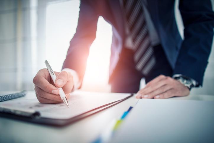 Man writing in suit and tie