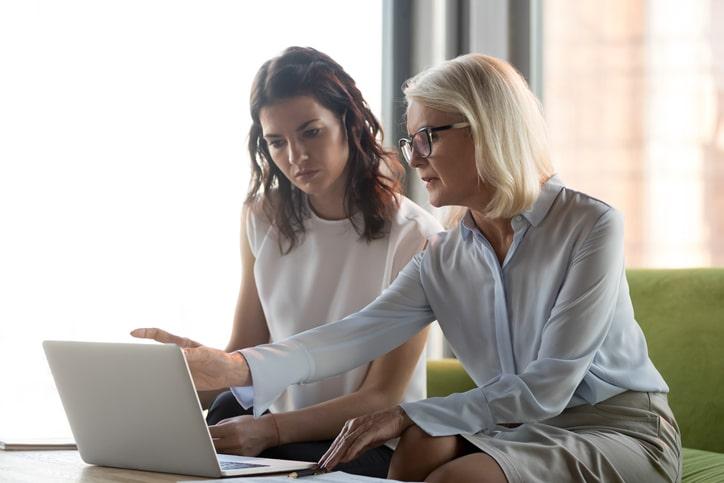 Two people working on a laptop