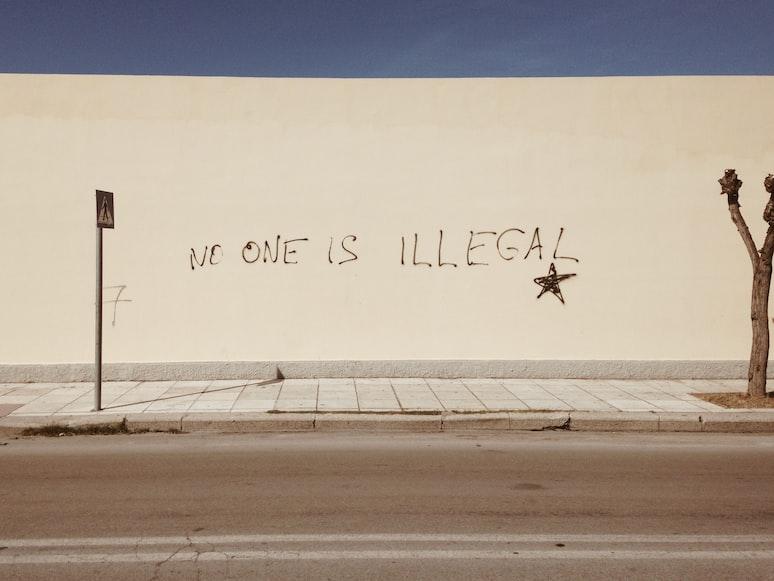graffiti on wall saying no one is illegal
