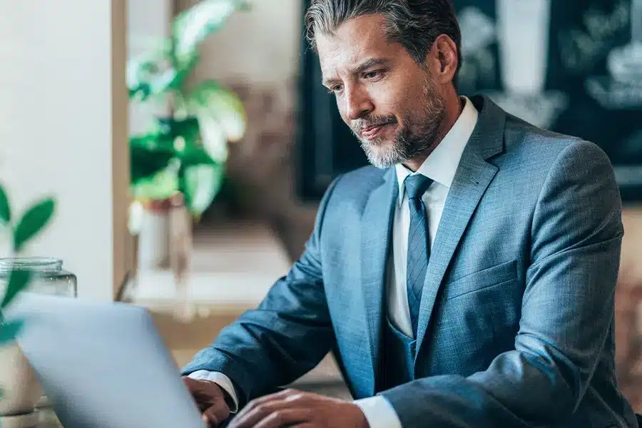 Man working on laptop in suit and tie