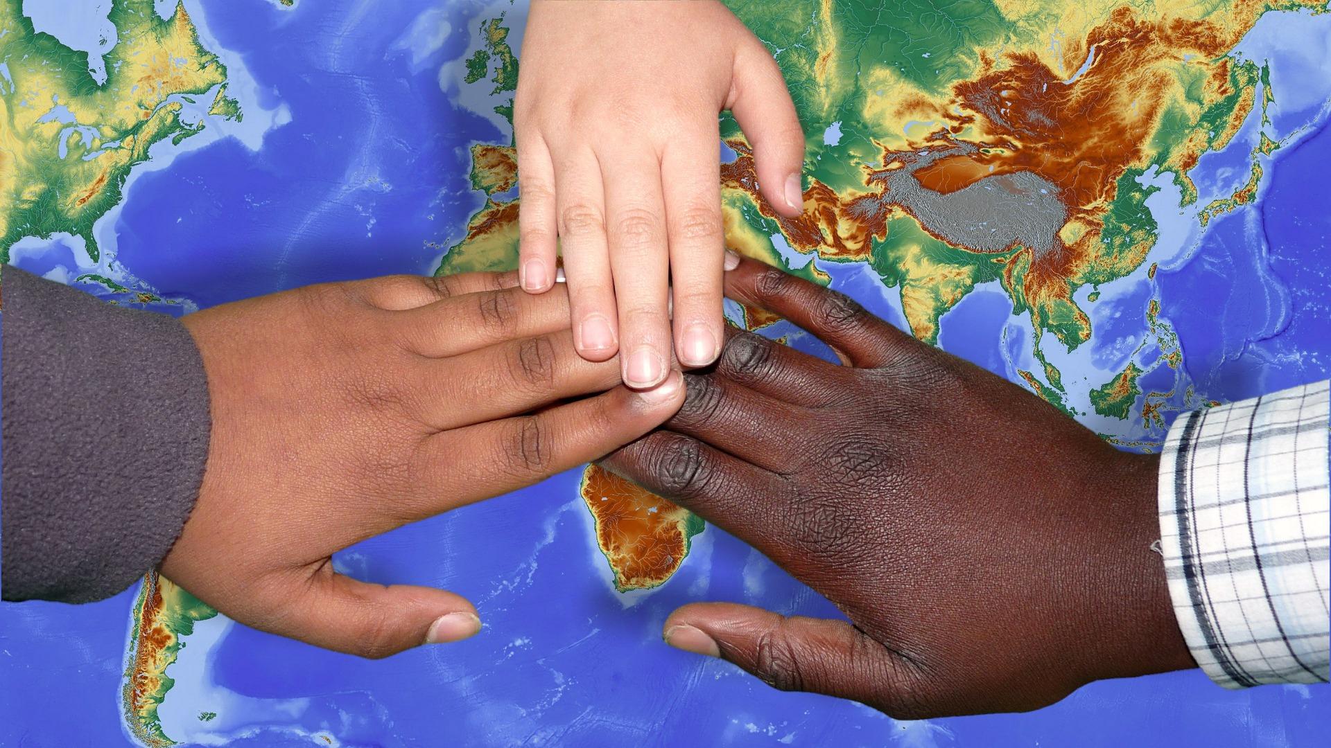 holding hands around a globe