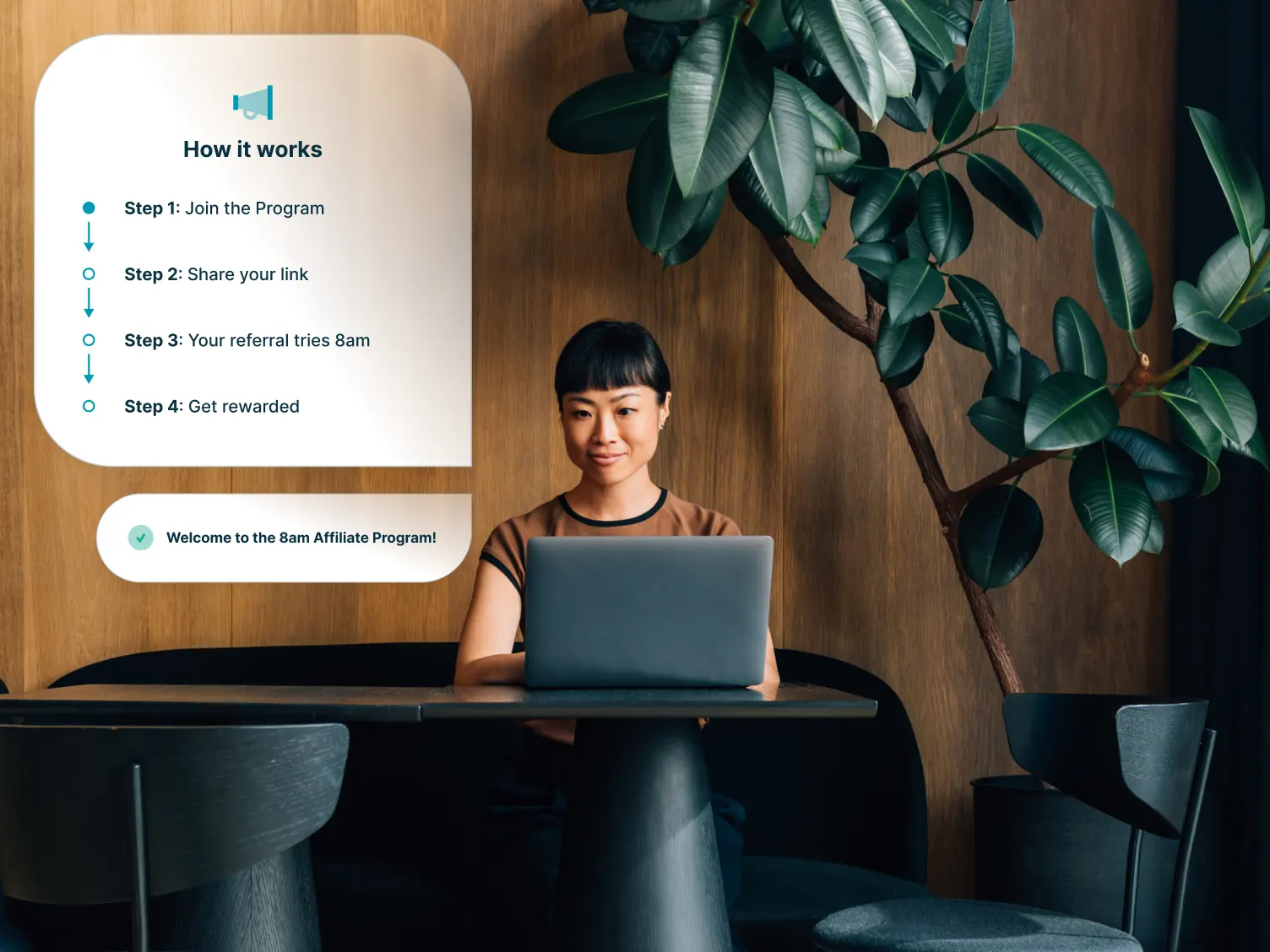 Woman working on laptop in an aesthetic office space.