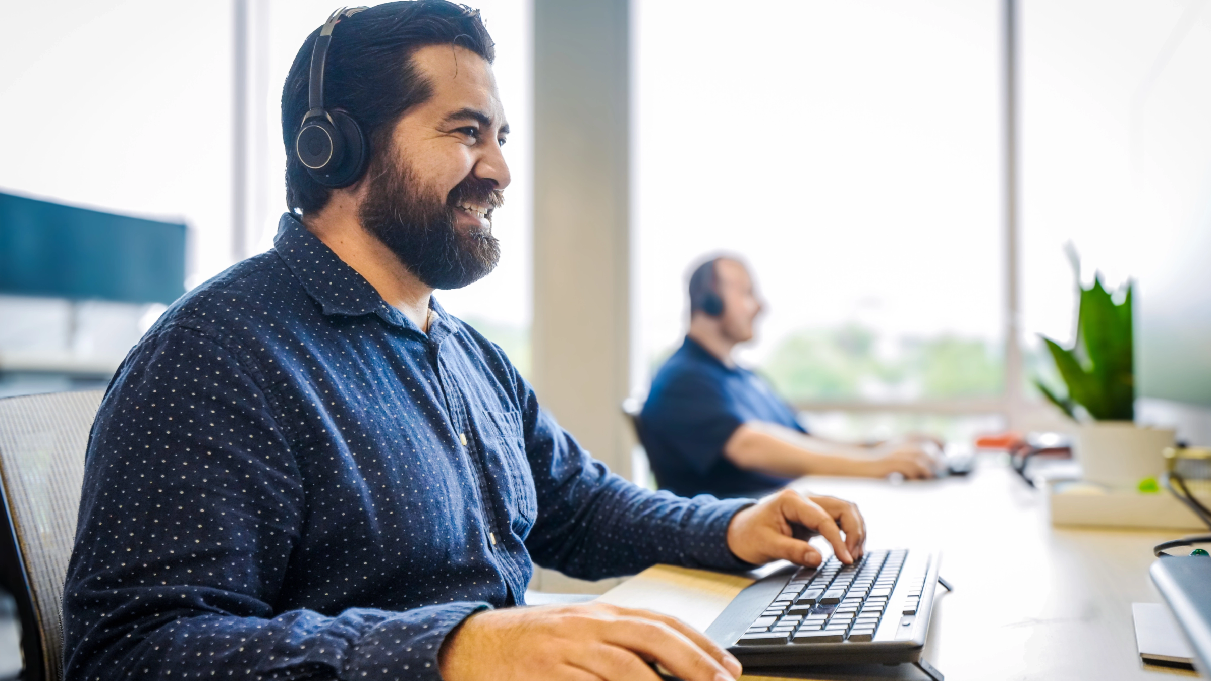 Man smiling at computer with headset on