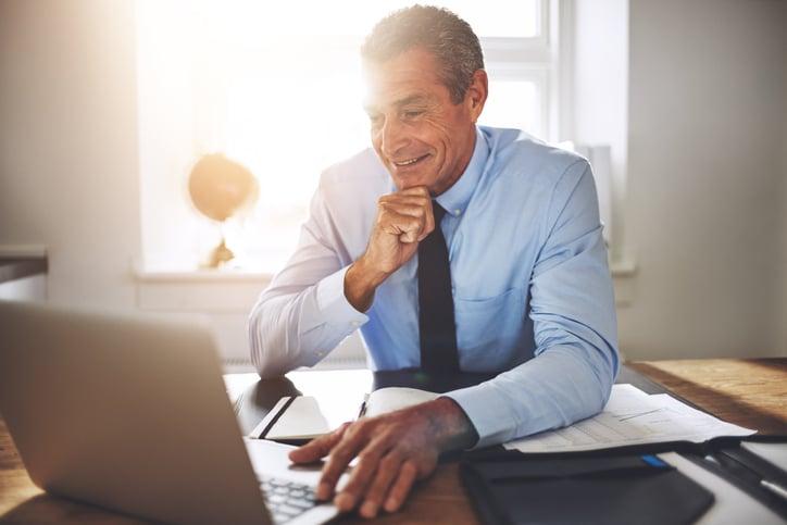 Man smiling looking at laptop