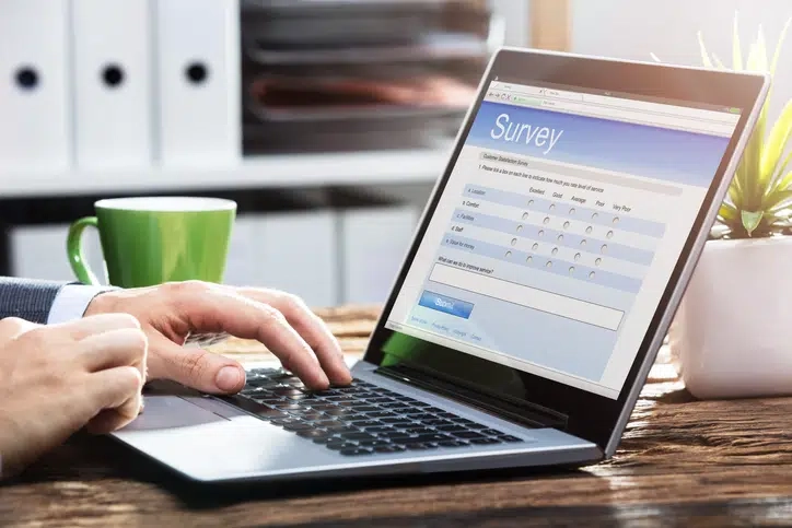 Person typing on laptop with coffee mug
