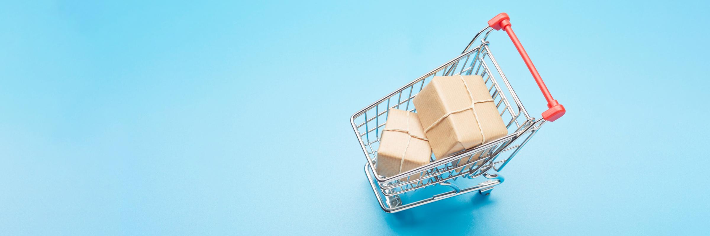 A shopping cart containing boxes seen from above on a bright blue background.