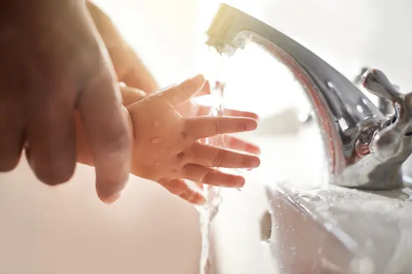 dad helping his child wash their hands