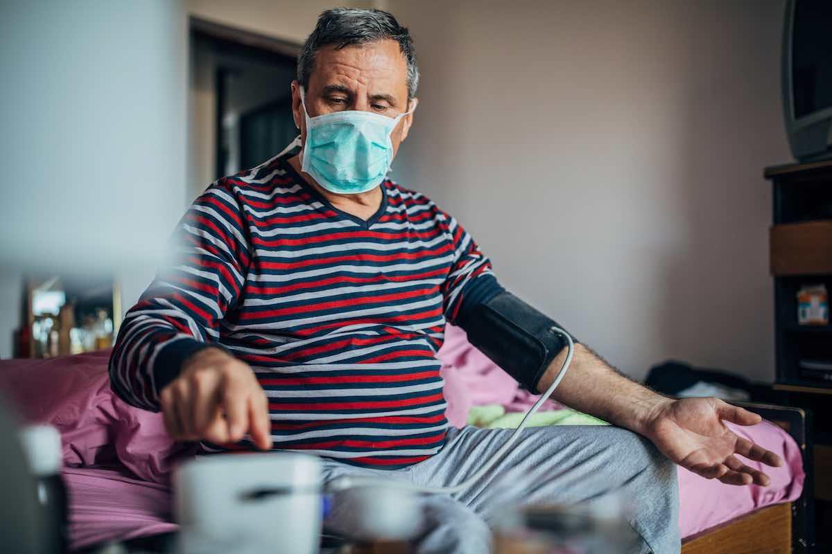 Man with Covid-19 takes his blood pressure at home, how COVID-19 affects the heart