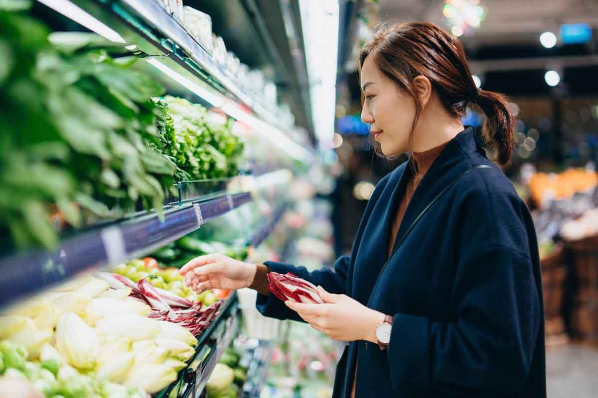 A woman choosing produce at the supermarket for a heart-healthy diet