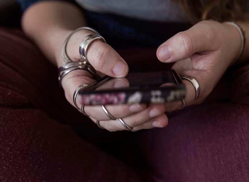 Young woman with ring splints uses her phone