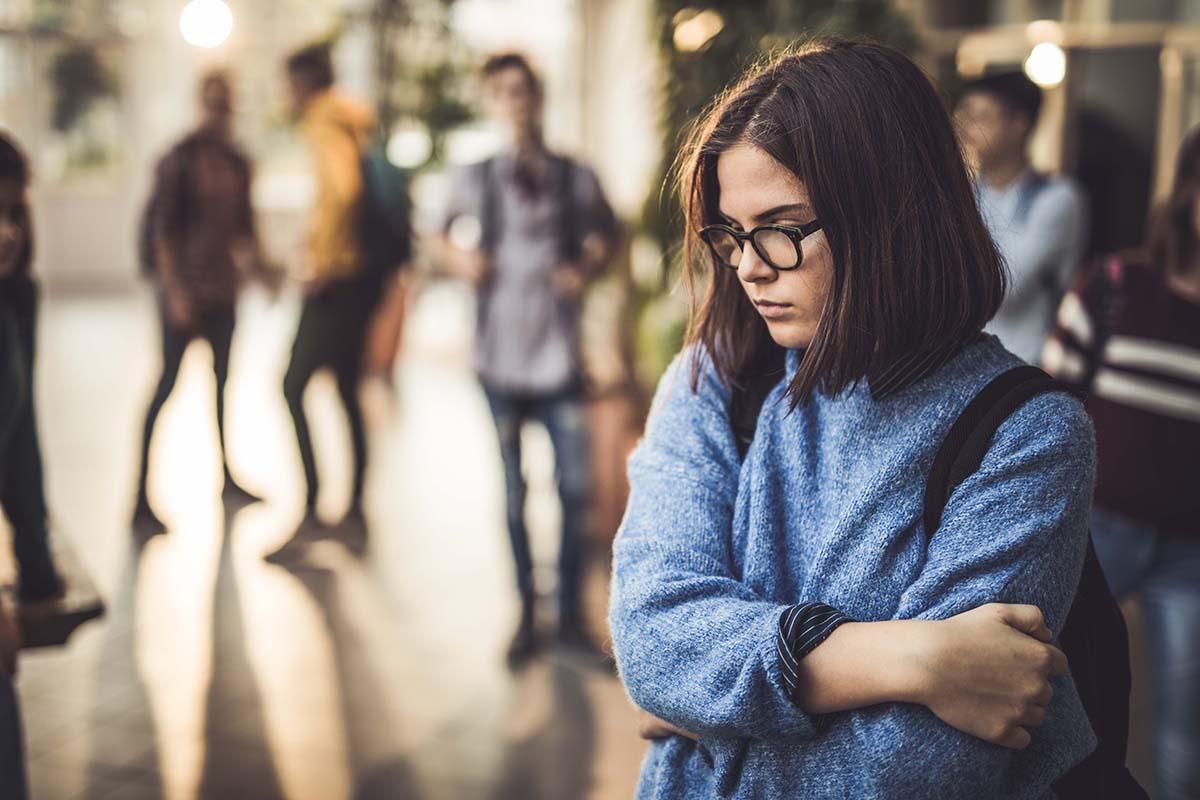 teenage girl in blue sweater looks depressed 