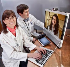 Karen S. Rheuban Center for Telehealth Co-Founder and Director Karen Rheuban, MD, and Andrew Southerland, MD consult with a patient using telehealth technology