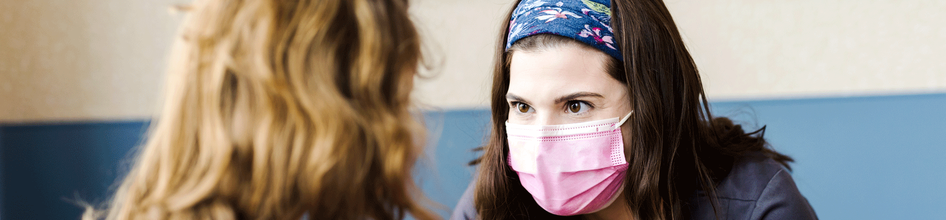 A healthcare provider and young girl facing each other.