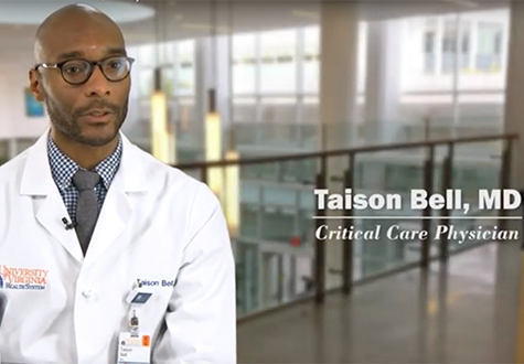 Taison Bell is sitting in the UVA medical center in a white coat. 