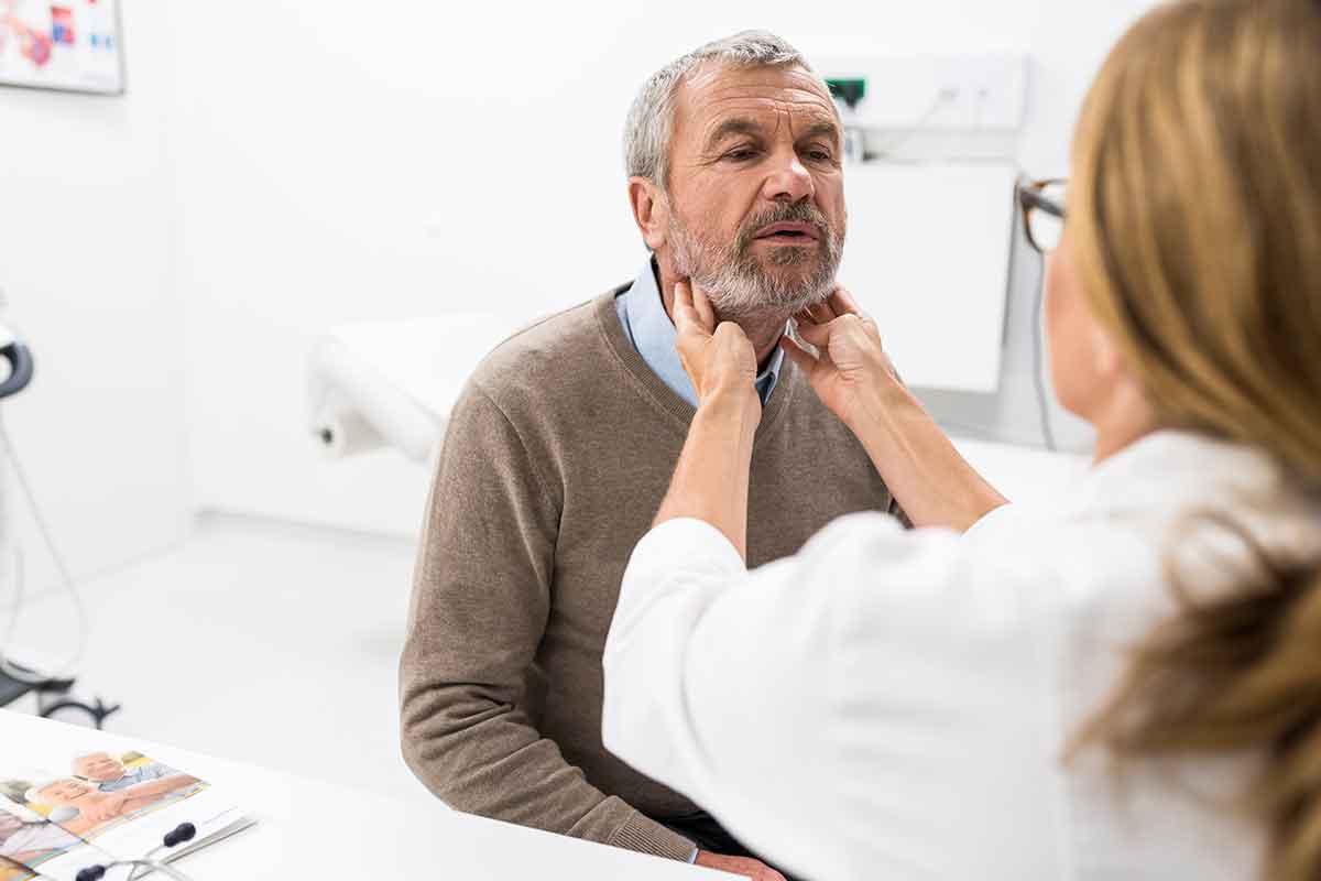 A middle-aged man gets his throat examined. HIs GERD could be a sign of esophageal cancer.