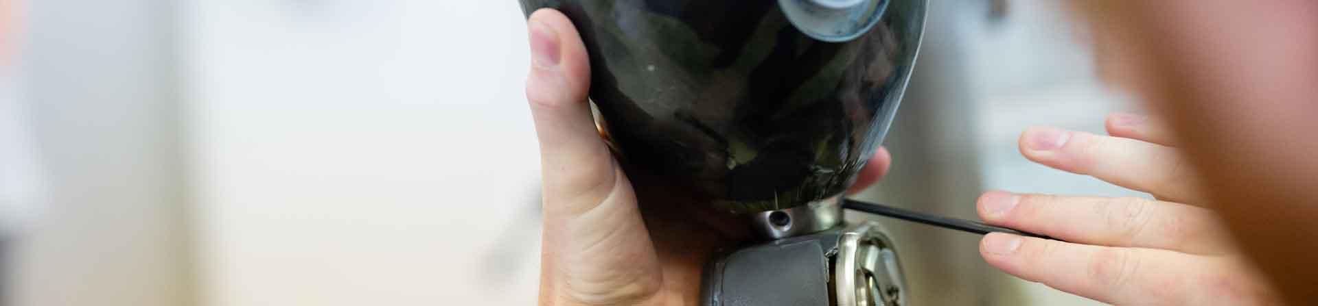 A prosthetics and orthotics expert using a tool to adjust a prosthetic device.