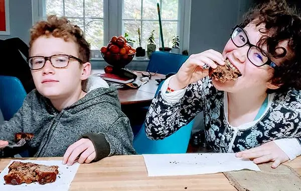 Both teens enjoyed the chocolate chip bread, even though one ate with a fork and the other crammed it in her mouth.