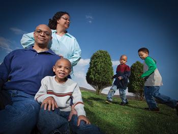 A family poses while their two younger sons play in the background