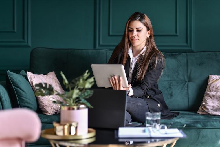 Woman in suit looks at tablet 