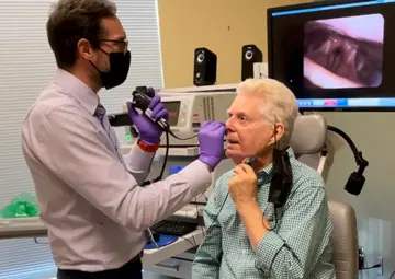 Dr. James Daniero performing laryngoscopy on a patient.