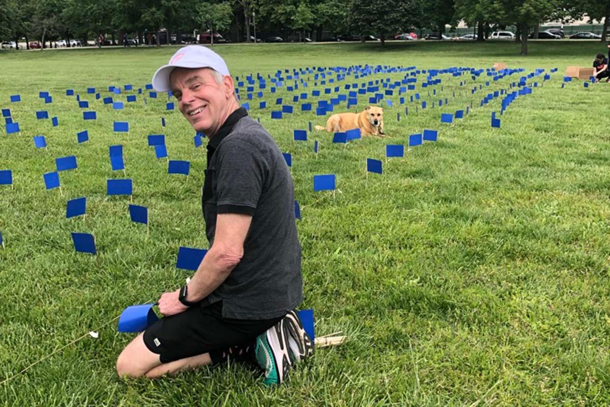 Jim Plews-Ogan, MD, helps place nearly 6,000 flags bearing the names of people with ALS on the National Mall at an awareness event. 