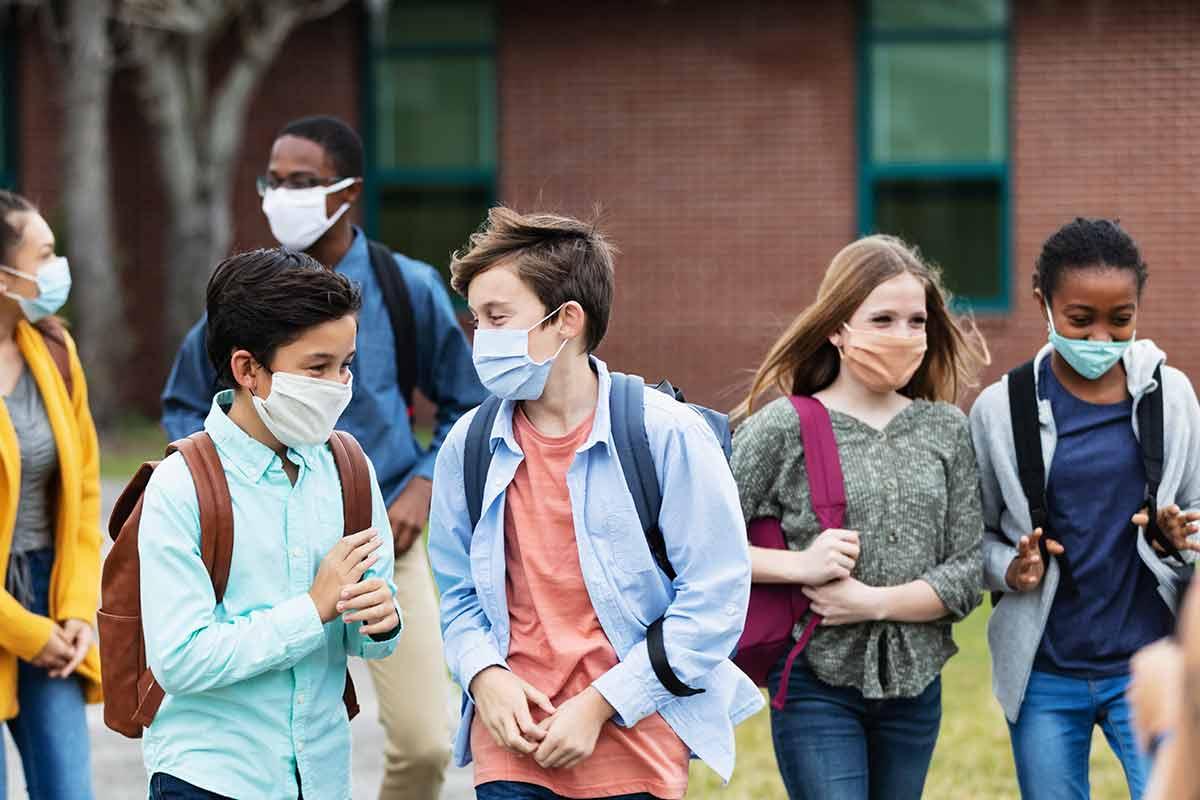 Several middle-schoolers outside of a school