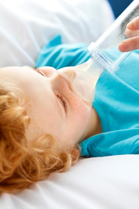 Little boy breathes through nebulizer during asthma attack