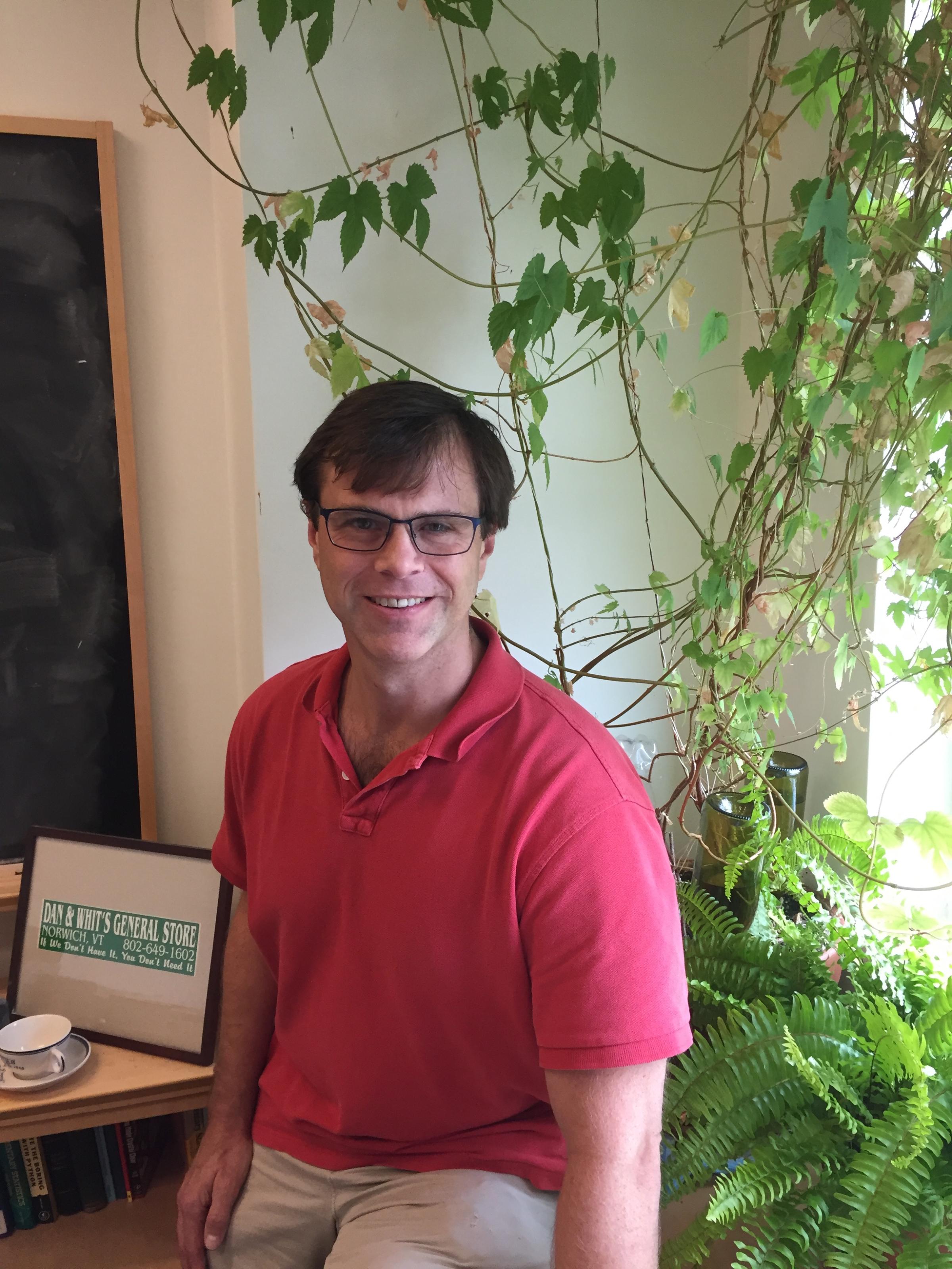 Christopher Stroupe, PhD, with a hops plant, of the type used to make beer. The plant is unrelated to his work, but he enjoys the pun.