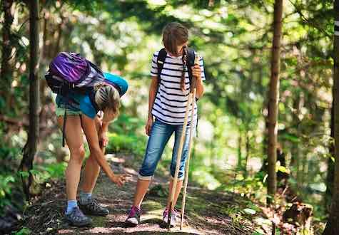 Mother applying tick repellent on daughter