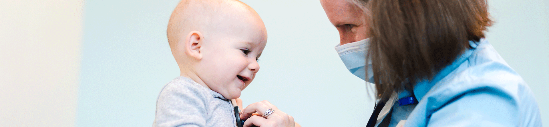 A healthcare provider listening to a toddler boy's chest.