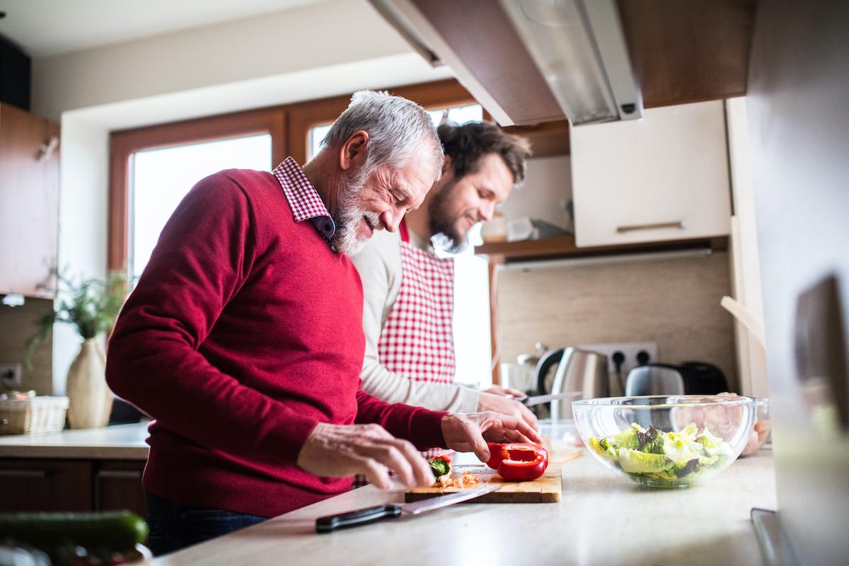 Son and father cooking a healthy meal, heart health tips