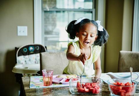 Young girl fixes herself food joyfully