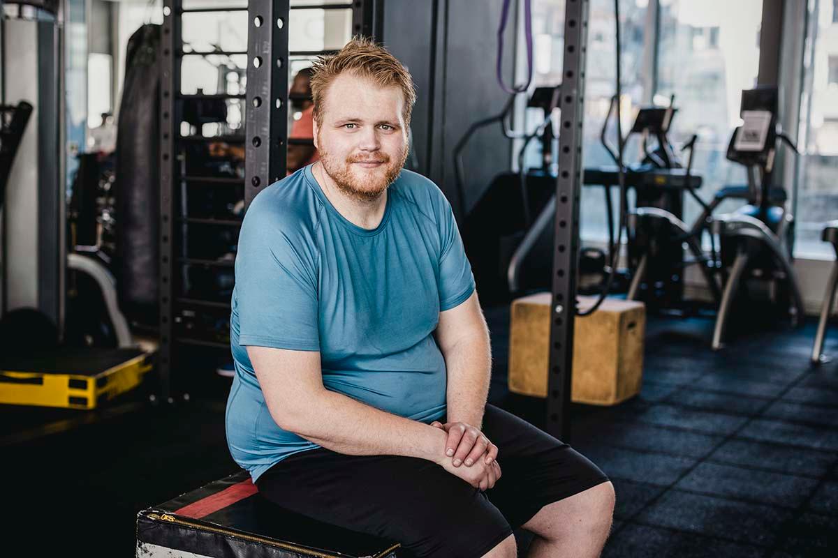overweight man at the gym, where he might experience fatphobia