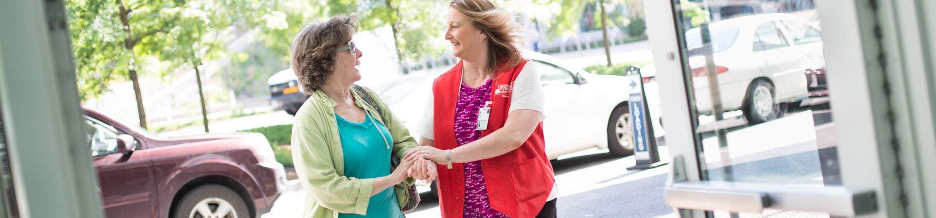 volunteer greeting patient at front door