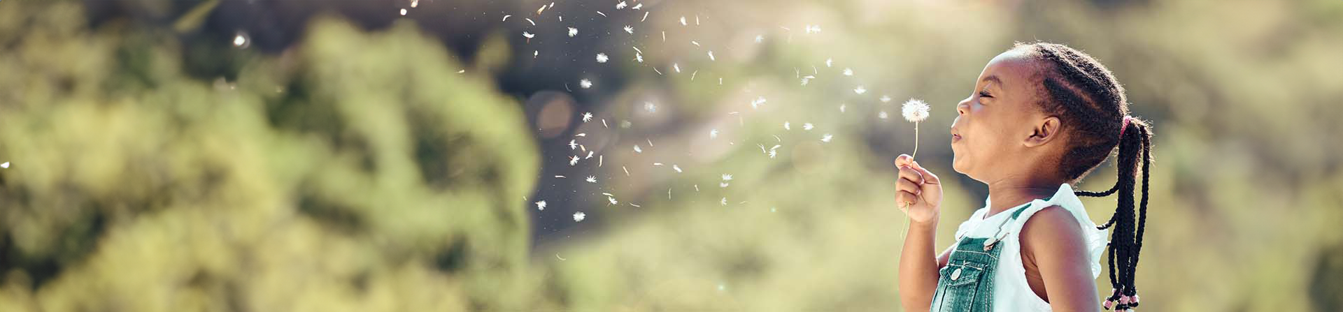 Girl blowing fluff off of Dandelion