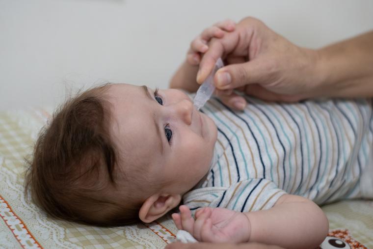 A baby receives a droplet vaccine to prevent rotavirus, a common cause of childhood diarrhea.