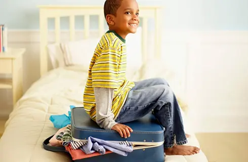 child packing suitcase