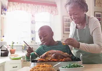 woman and her grandson keep dishes separate for Thanksgiving guests with food allergies