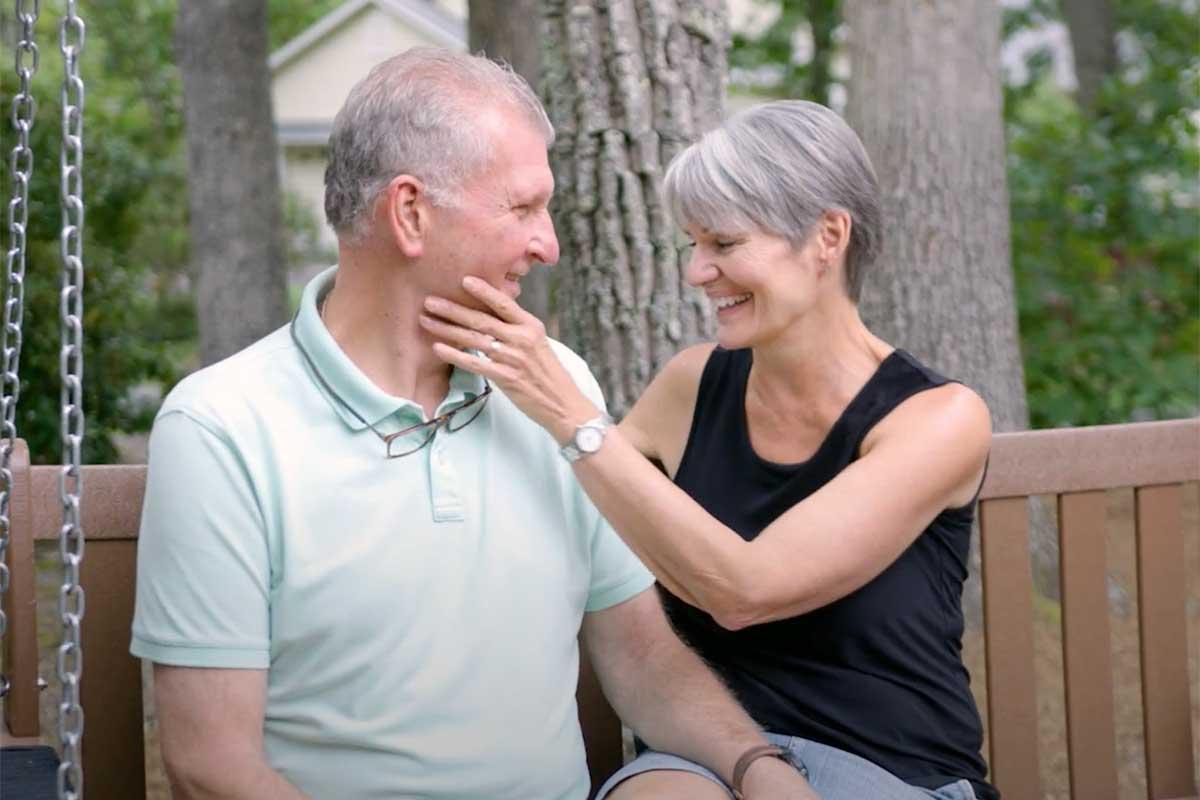 Aquablation patient David sit with his wife on a swing, happy after the procedure