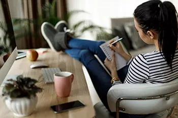woman making personal preparedness list at home